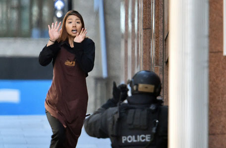 One of the hostages runs towards police from a cafe in the central business district of Sydney on December 15, 2014. (AFP)