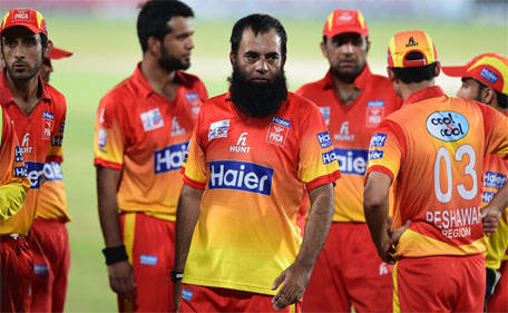 This photo taken on September 14, 2015 shows Peshawar cricket coach Abdul Rehman (centre) standing with players during the National Twenty20 semi-final against Sialkot at the Rawalpindi Cricket Stadium in Rawalpindi. (AFP)