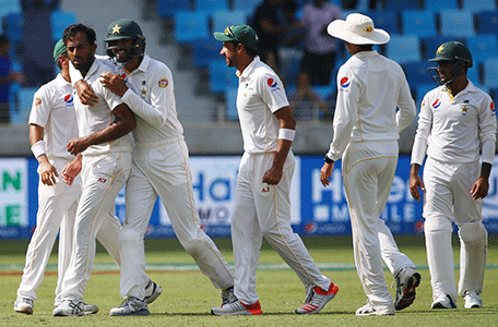 Pakistan's Wahab Riaz (L) celebrates with his teammates after dismissing England's Stuart Broad during the fifth and last day of the second Test cricket match between Pakistan and England in Dubai on October 26, 2015. AFP