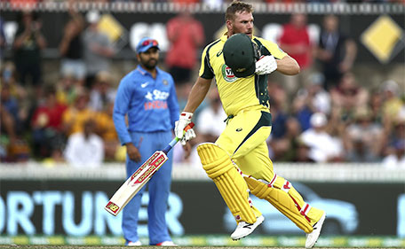 Australian batsman Aaron Finch takes his helmet off as he checks the ball he hit to reach a century during the team's One Day International cricket match against India in Canberra, Australia, Wednesday, Jan. 20, 2016. (AP)