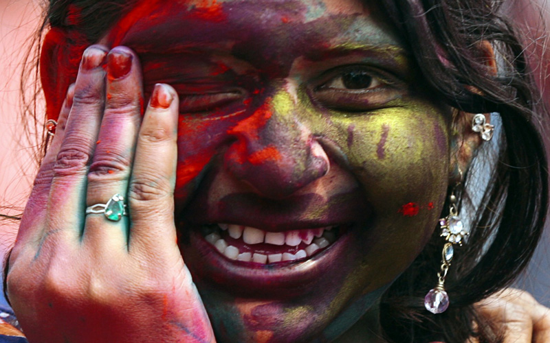 A woman daubed in colours smiles as she celebrates Holi, also known as the festival of colours, at a slum in the eastern Indian city of Siliguri. This tradition heralds the beginning of spring and is celebrated all over India. (REUTERS)