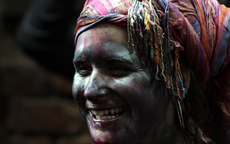 An Indian woman smeared with colors smiles as she celebrates "Holi," the Indian festival of colors, in Calcutta, India. The festival also marks the coming of spring. (AP)