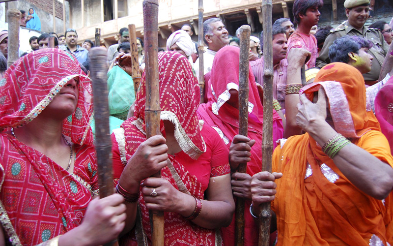 women with their faces covered hold bamboo sticks in a re-enactment of a local tradition of "Lathmar Holi", also known as the festival of colours, celebrated at Barsana in the northern Indian state of Uttar Pradesh. (REUTERS)