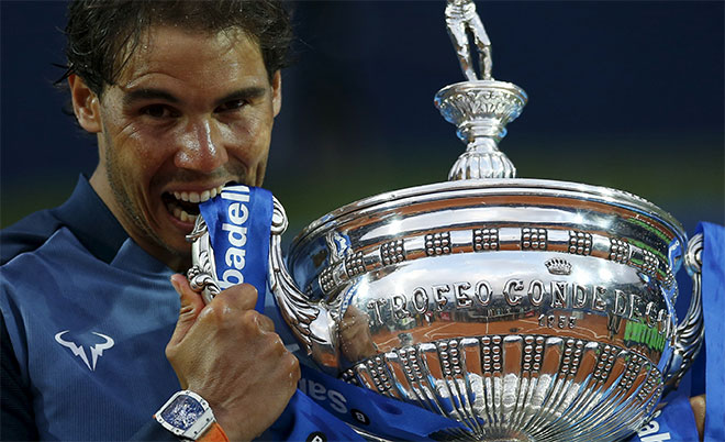 Rafael Nadal of Spain bites the Barcelona Open trophy after defeating Kei Nishikori of Japan in Barcelona, Spain, April 24, 2016. (Reuters)