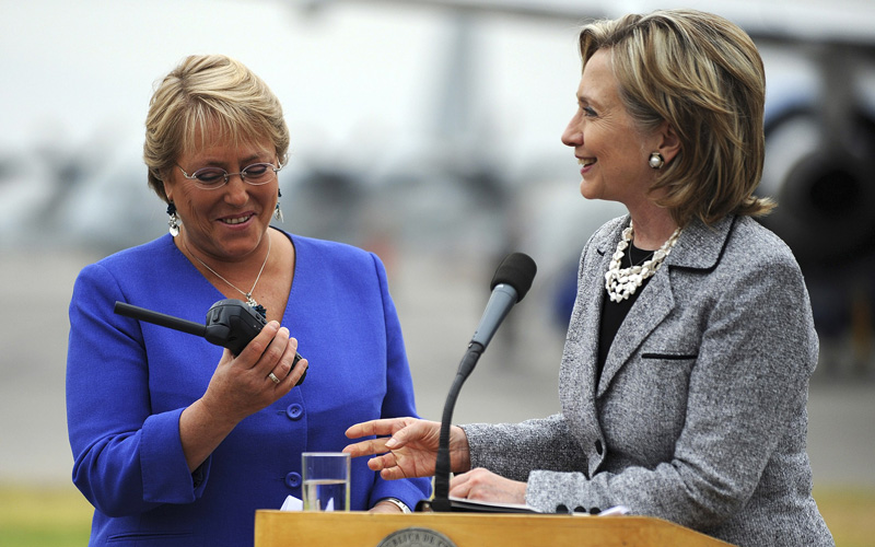 Chile's President Michelle Bachelet (L) inspects a satellite phone given to her by US Secretary of State Hillary Clinton after Clinton's arrival in Santiago March 2, 2010. Clinton arrived in Santiago with communications equipment to help the aid operations as Chilean troops patrolled in the wake of Saturday morning's 8.8-magnitude quake that killed more than 700 people. (REUTERS)