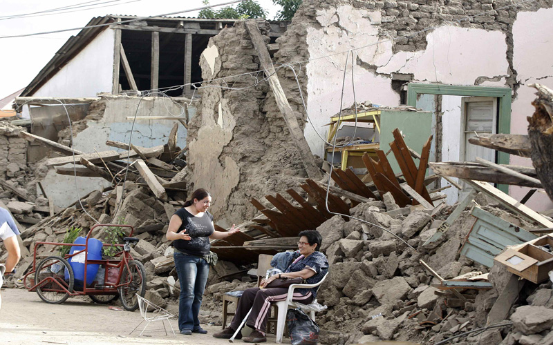 Survivors talk on a street in front of a building destroyed in a major earthquake in Talca. Chilean troops patrolled in the wake of Saturday morning's 8.8-magnitude quake that killed more than 700 people, while the government acknowledged that it has battled to provide aid swiftly because of crumpled highways and major power disruptions caused by the quake. (REUTERS)