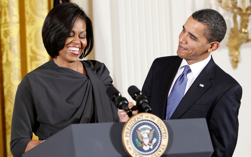 US President Barack Obama (R) looks at his wife, first lady Michelle Obama (L), as she speaks during a reception in honor of International Women’s Day at the East Room of the White House in Washington, DC. The reception honored women from around the world and their achievements. (GETTY IMAGES)